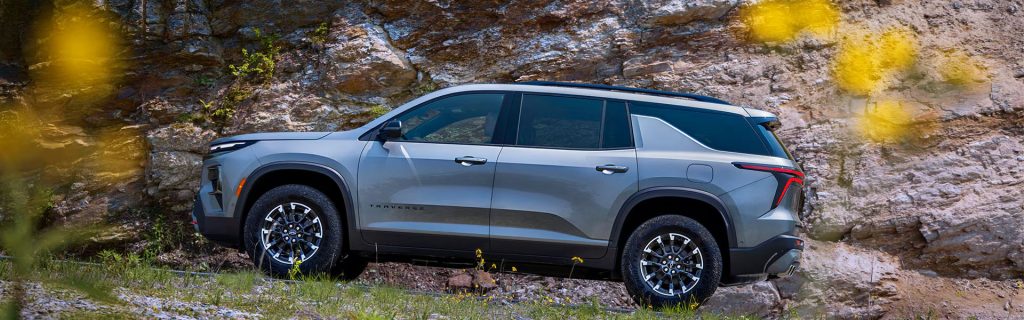 2026 Chevy Traverse SUV parked on rocky terrain, showcasing its rugged design.