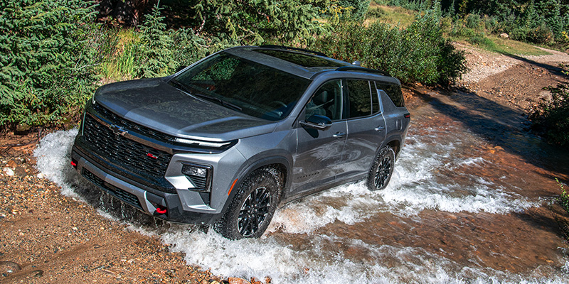 A 2026 Chevrolet Traverse drives through a stream, showcasing its rugged design in Peoria, AZ.